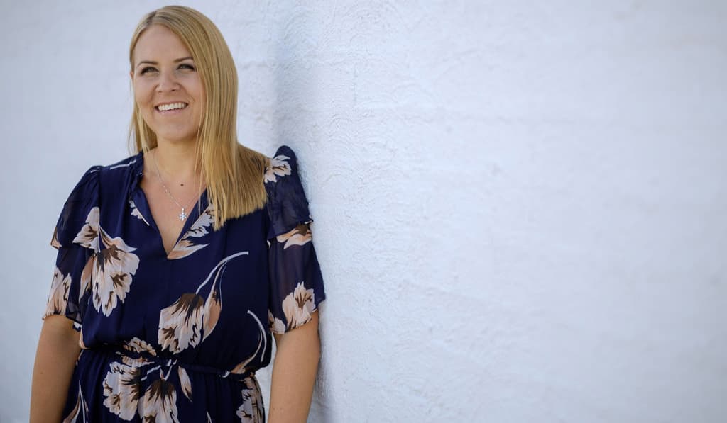 Brigitta Warren, RecruitNet founder, smiling against a white wall