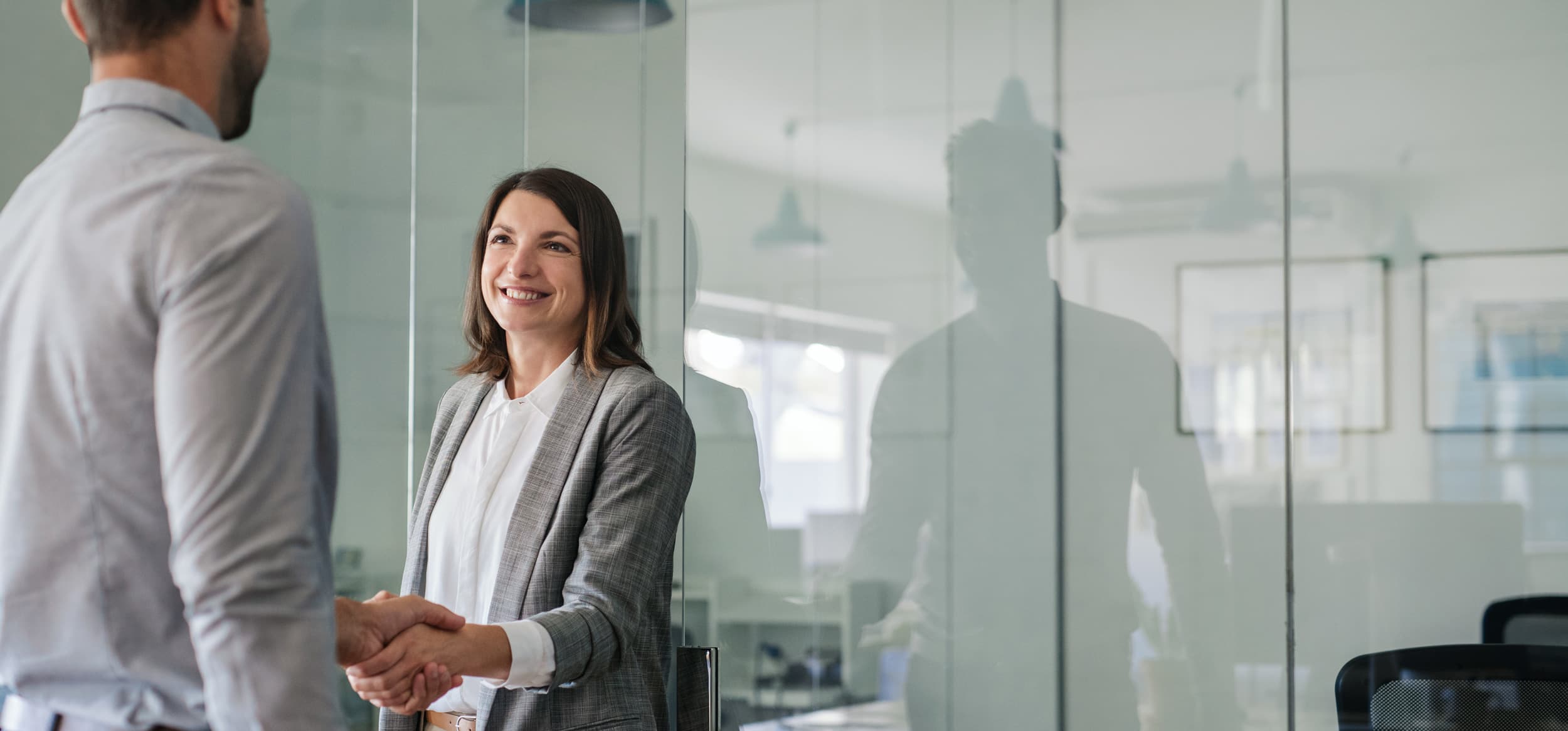 Manager and employee shaking hands after a performance review meeting